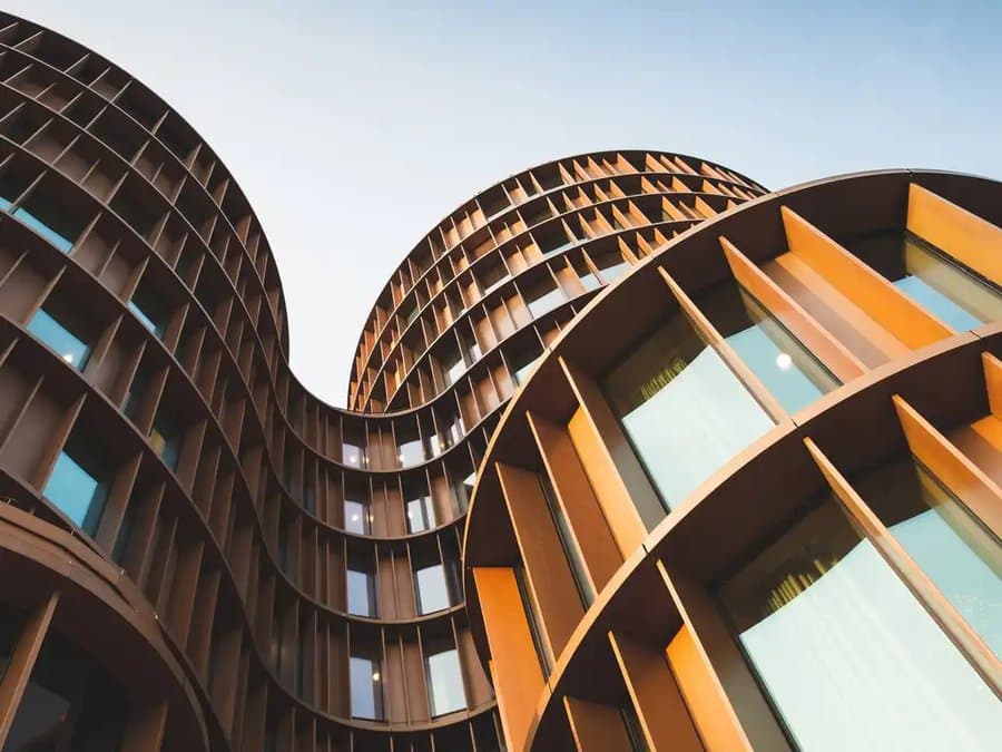 Futuristic curved corten steel building facade, modern construction architecture